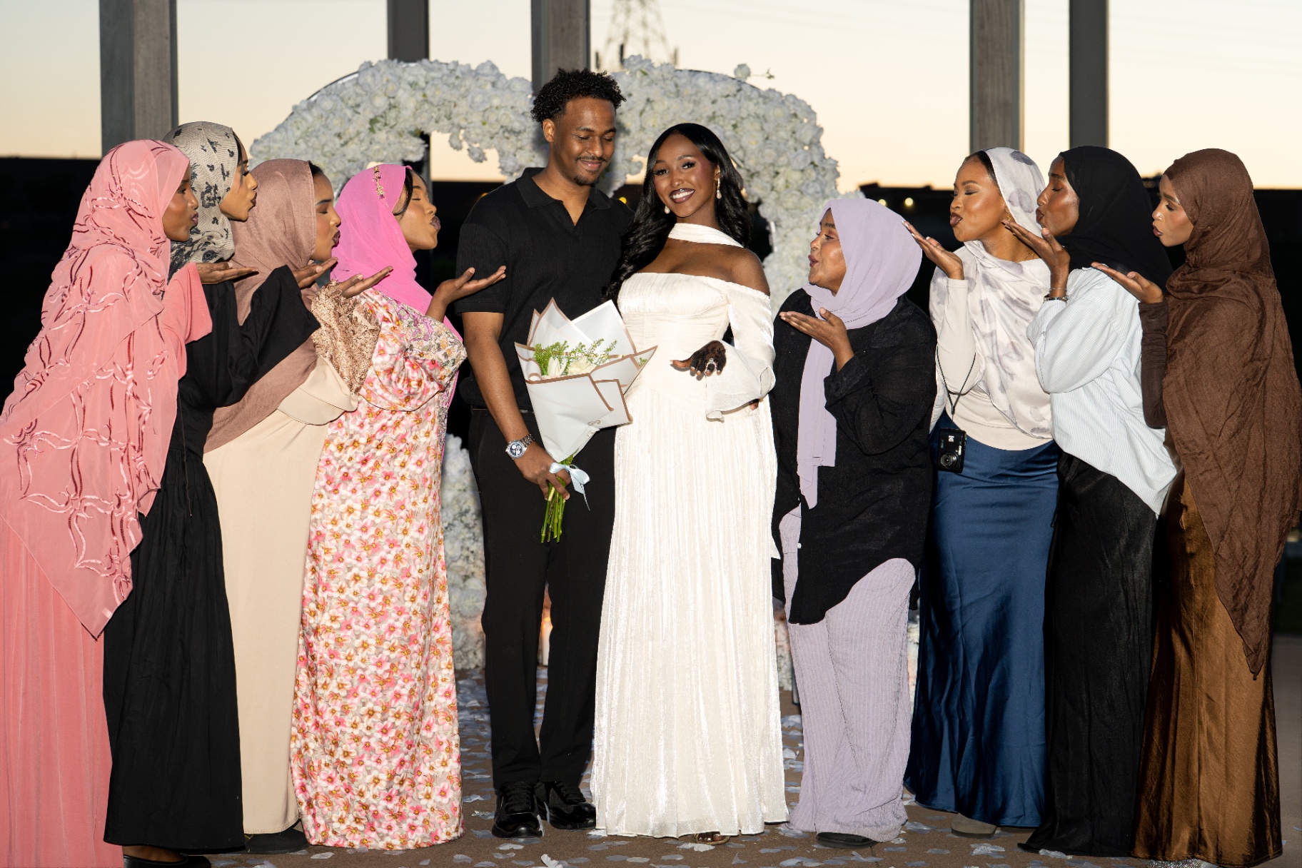Surrounded by family blowing kisses